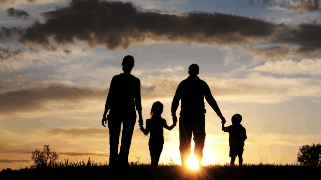 Family walking together over a hill into a sunrise under stormy skies, symbolizing hope, unity, and a fresh start on their journey to financial security.